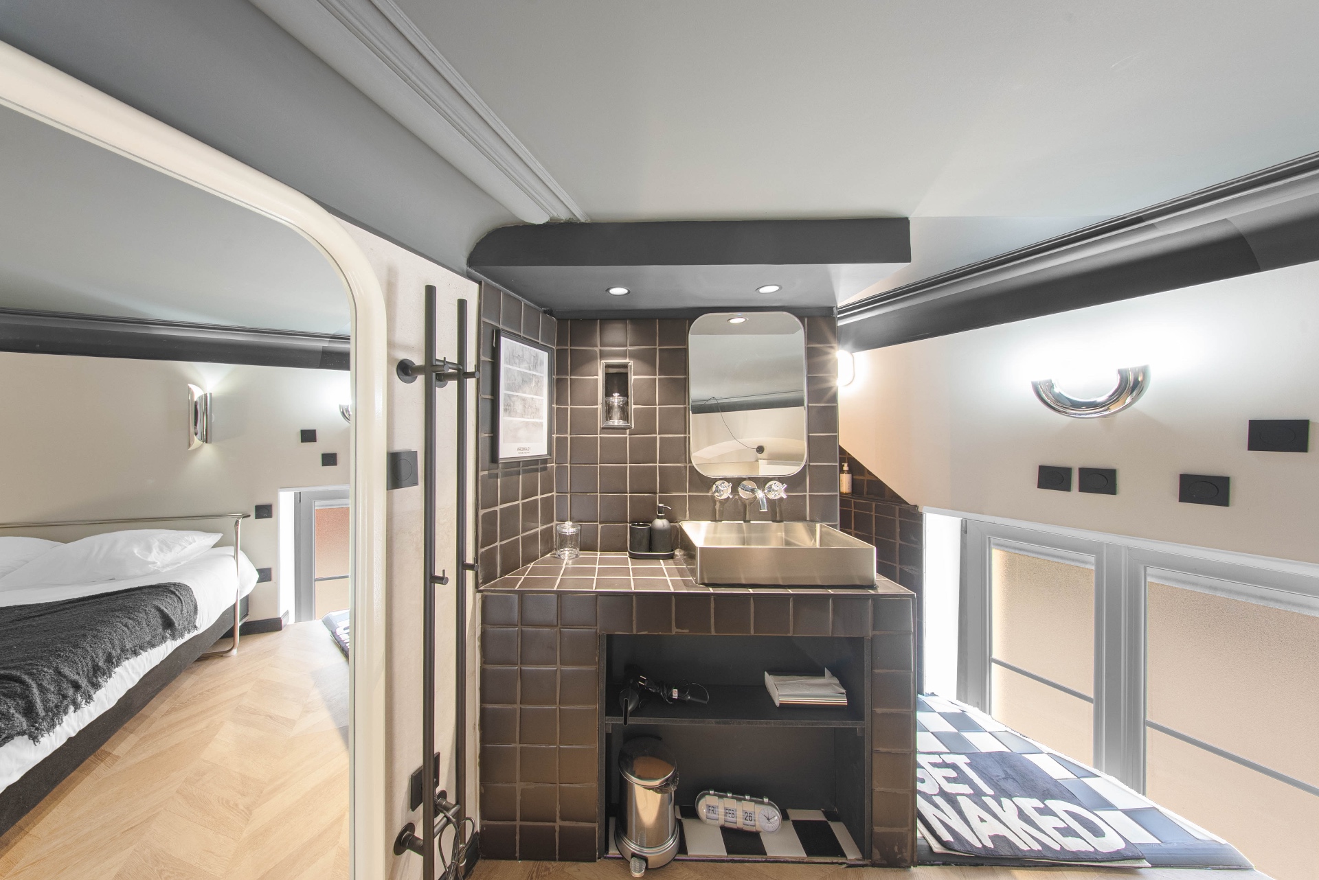 Salle d'eau en mezzanine avec vasque inox et carrelage brun