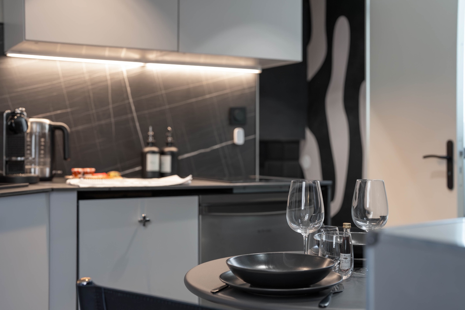 Cuisine équipée du Loft d'Artiste avec verres à vin et art mural